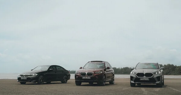Three BMW vehicles parked on an open field.